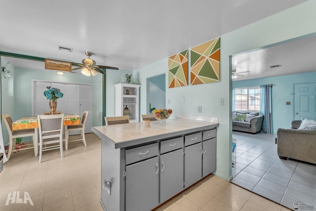 kitchen featuring open floor plan, a peninsula, light countertops, and visible vents