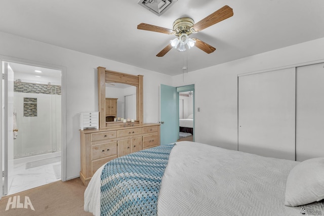 bedroom with a closet, visible vents, light carpet, ceiling fan, and ensuite bath