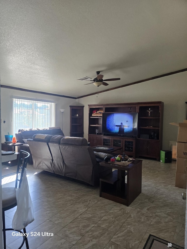 living room featuring ceiling fan, ornamental molding, and a textured ceiling