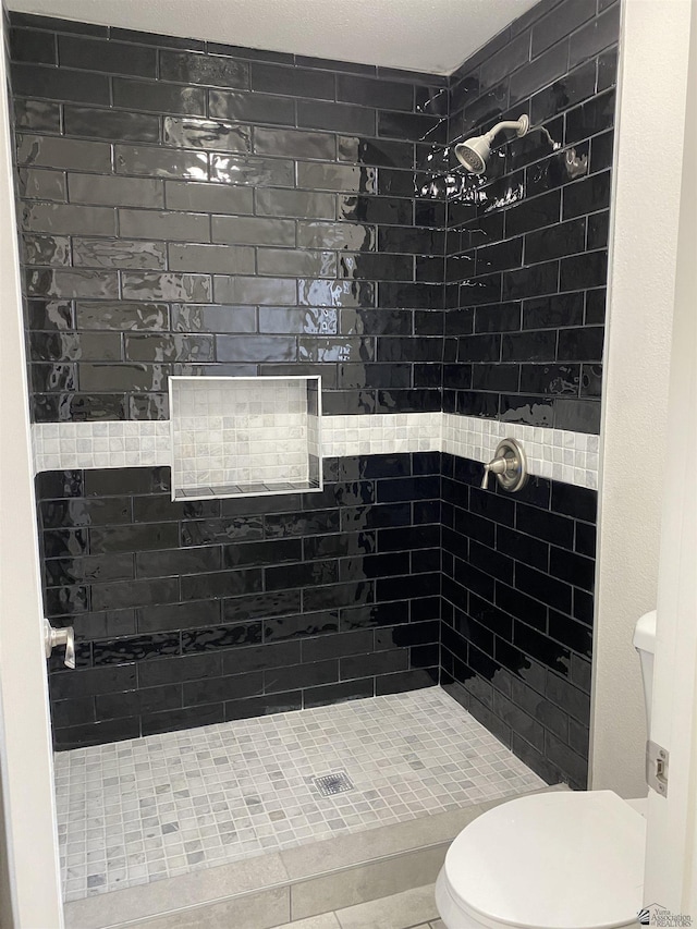 bathroom with tiled shower and toilet