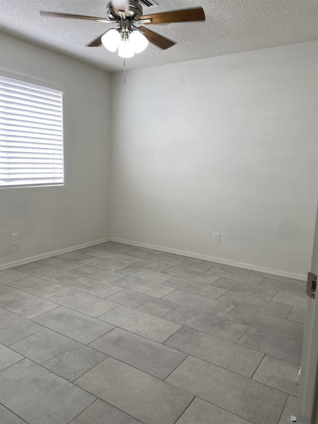 tiled spare room with a textured ceiling