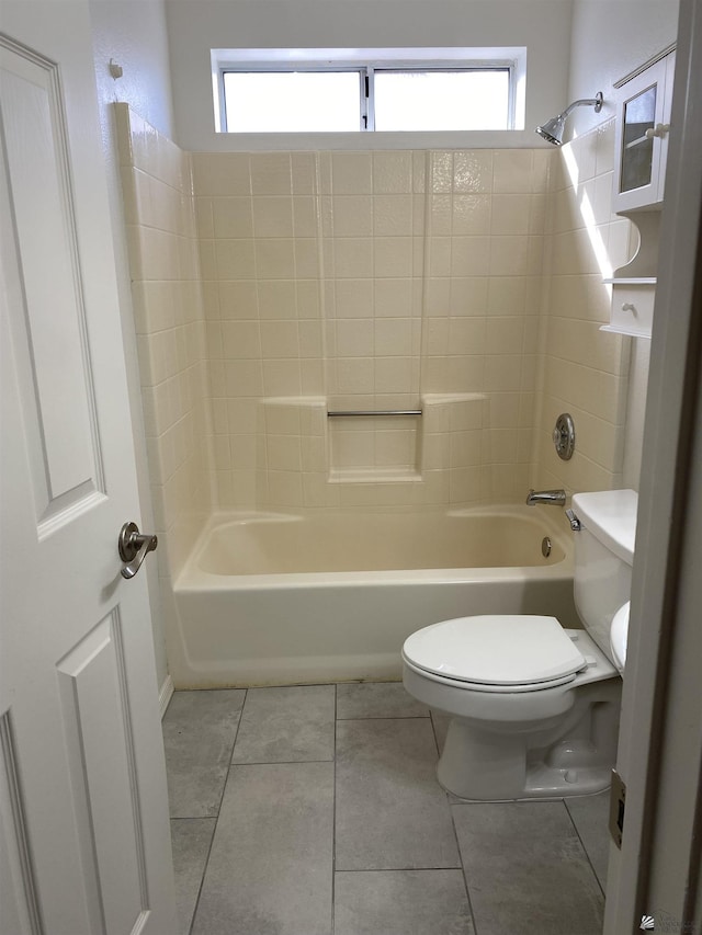 bathroom featuring tile patterned floors, toilet, shower / bathing tub combination, and a wealth of natural light