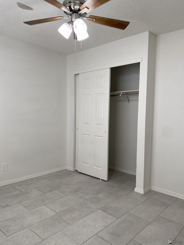 unfurnished bedroom with ceiling fan, a textured ceiling, and a closet