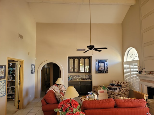 tiled living room featuring ceiling fan and high vaulted ceiling