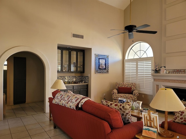 tiled living room featuring a high ceiling and ceiling fan