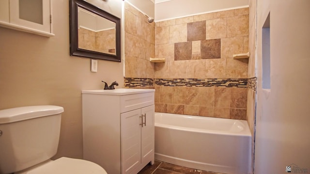 full bathroom featuring tile patterned flooring, vanity, tiled shower / bath combo, and toilet