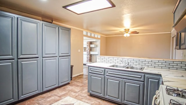 kitchen with backsplash, white gas range oven, sink, ceiling fan, and light stone countertops