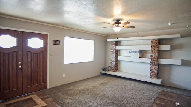 carpeted foyer entrance featuring a textured ceiling and ceiling fan