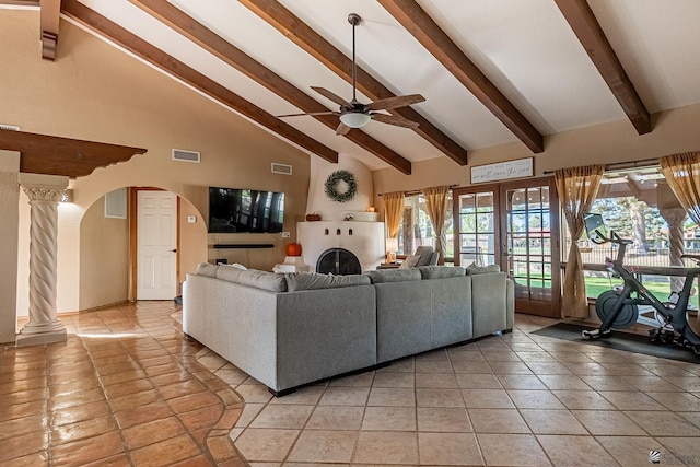 unfurnished living room with ornate columns, ceiling fan, plenty of natural light, and high vaulted ceiling