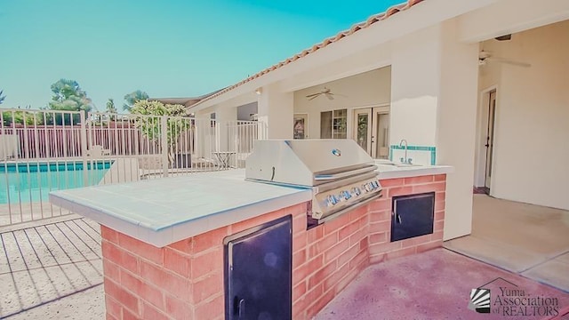 view of patio / terrace with grilling area, a fenced in pool, fence, exterior kitchen, and a ceiling fan