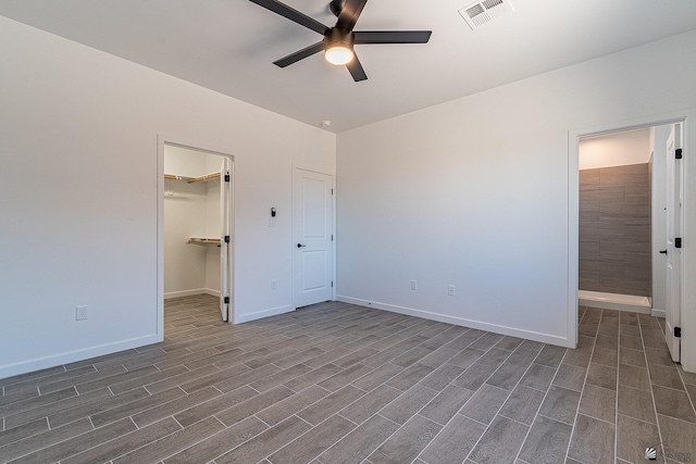 unfurnished bedroom with a closet, a spacious closet, and ceiling fan