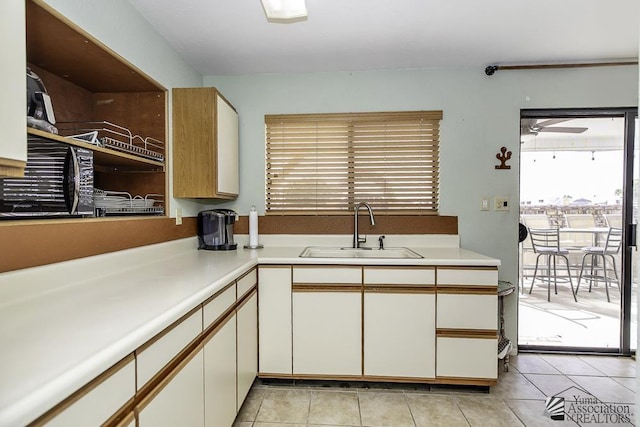 kitchen featuring white cabinetry, sink, and light tile patterned floors