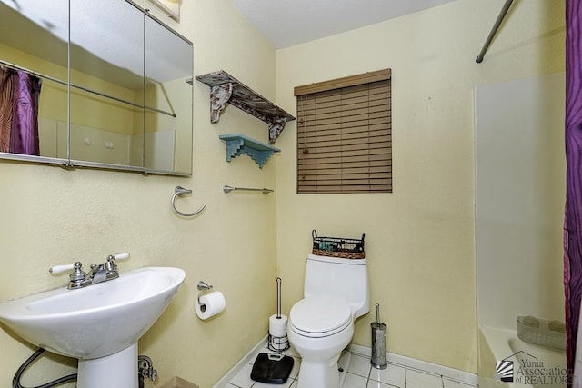 full bathroom with shower / tub combo with curtain, sink, tile patterned flooring, and toilet