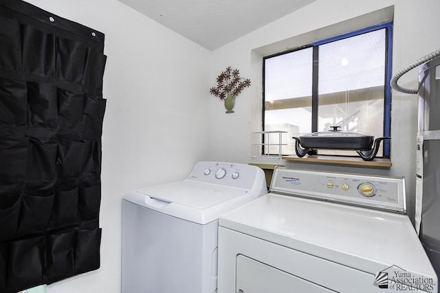 clothes washing area with washer and clothes dryer and secured water heater