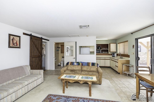 tiled living room featuring a barn door and sink