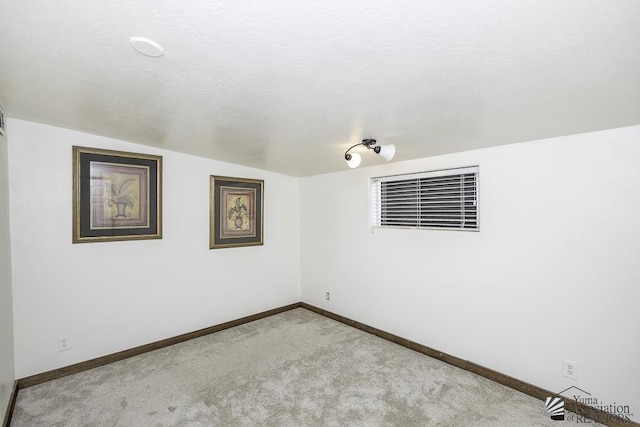 carpeted spare room featuring a textured ceiling