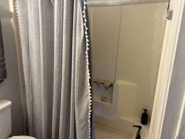 bathroom with toilet and a shower with curtain