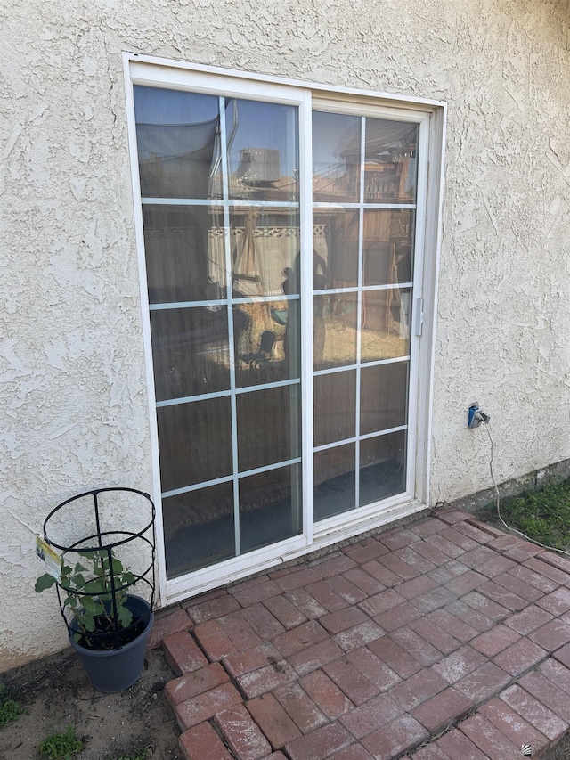 view of exterior entry with a patio area