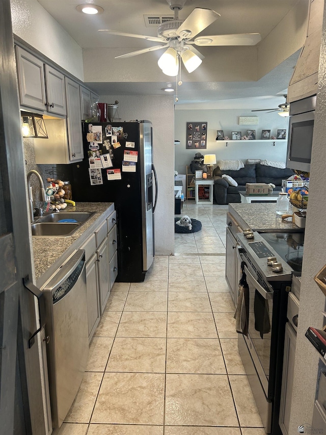 kitchen featuring light tile patterned floors, appliances with stainless steel finishes, gray cabinets, and sink