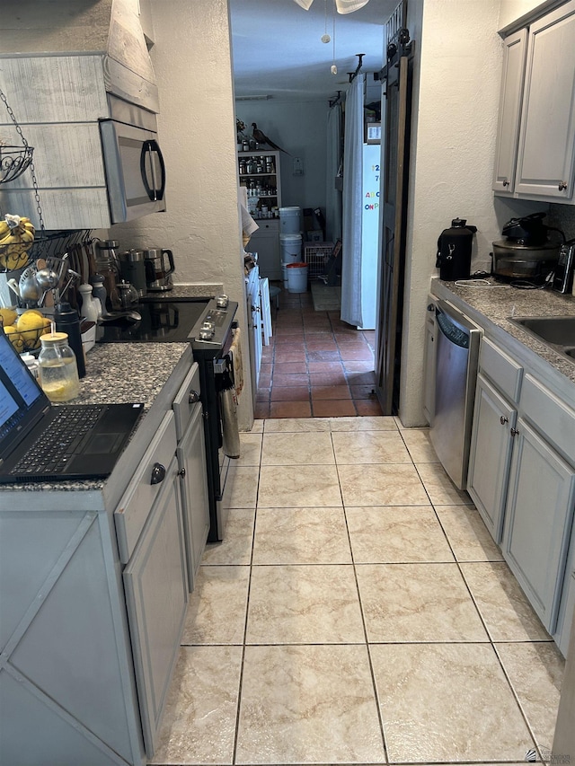 kitchen with light tile patterned floors, sink, gray cabinets, and stainless steel appliances