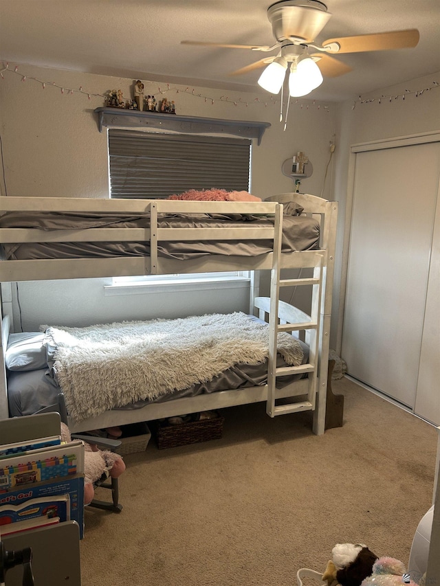 bedroom with ceiling fan, a closet, and carpet flooring