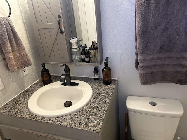 bathroom featuring toilet and vanity