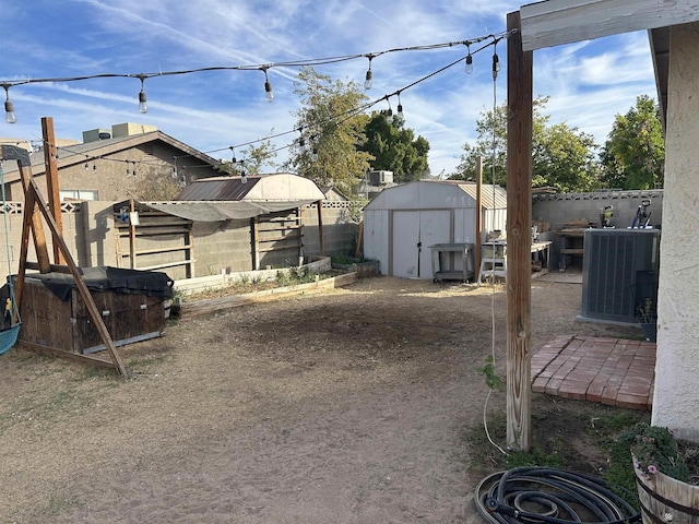 view of yard featuring a storage shed and central AC