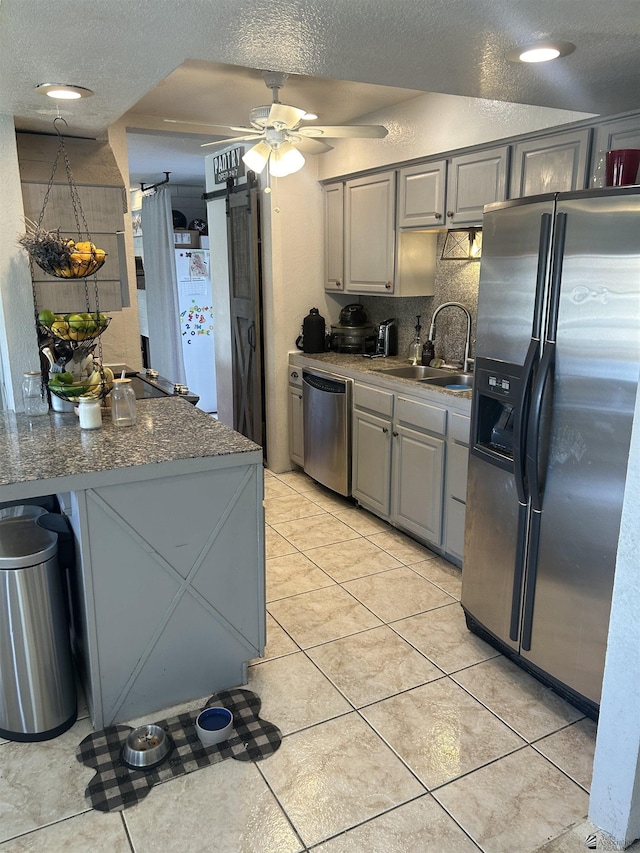 kitchen featuring gray cabinets, appliances with stainless steel finishes, ceiling fan, and sink