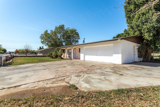 view of front of house with a garage, concrete driveway, and stucco siding