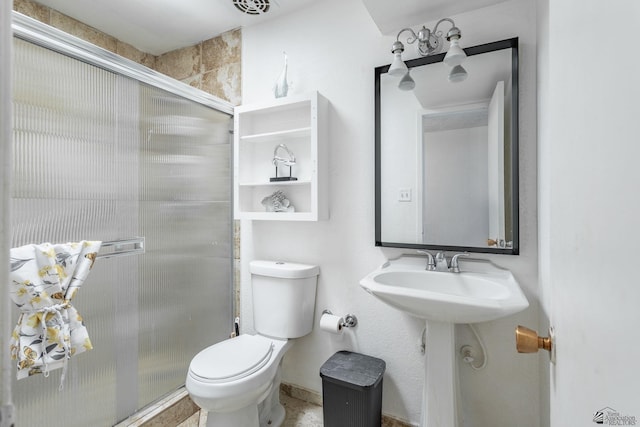 bathroom with toilet, a shower stall, and a sink