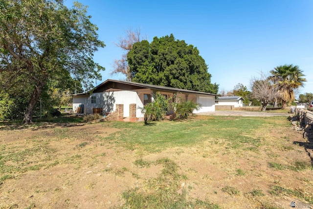 view of front of property with an attached garage, driveway, and a front lawn