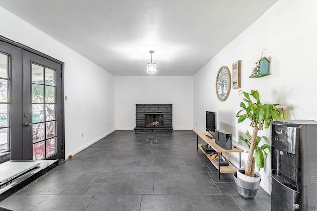 unfurnished living room with a fireplace, baseboards, and french doors