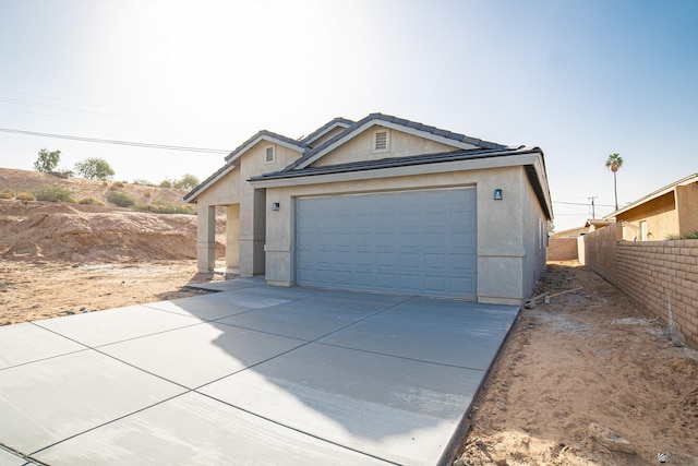 garage featuring fence and driveway