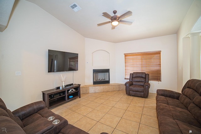 living room featuring a tiled fireplace, ceiling fan, and light tile patterned floors