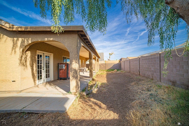 view of exterior entry with french doors and a patio