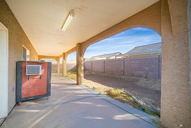 view of patio / terrace featuring an AC wall unit