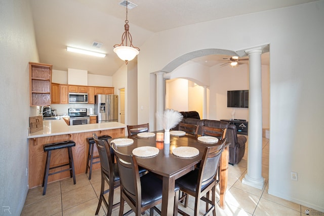 tiled dining area featuring ceiling fan, lofted ceiling, and sink