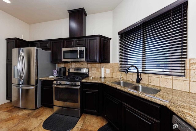 kitchen featuring tasteful backsplash, appliances with stainless steel finishes, sink, and light stone counters