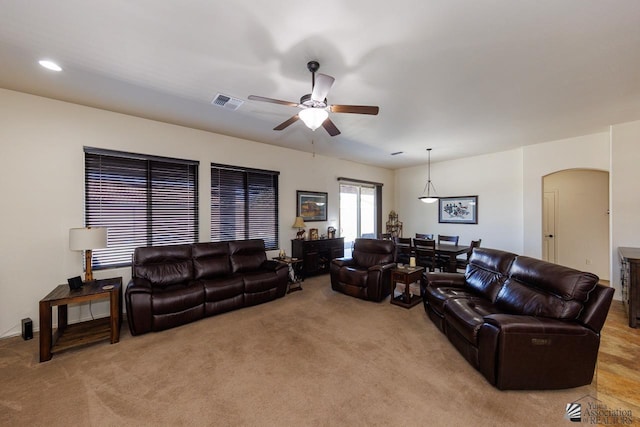 living room featuring light colored carpet and ceiling fan