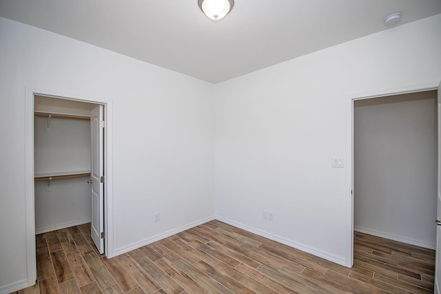 unfurnished bedroom with a walk in closet and a closet