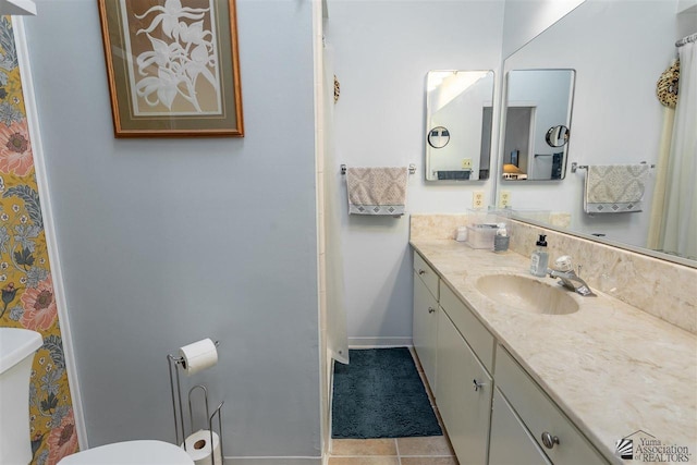 bathroom featuring vanity, tile patterned floors, and toilet