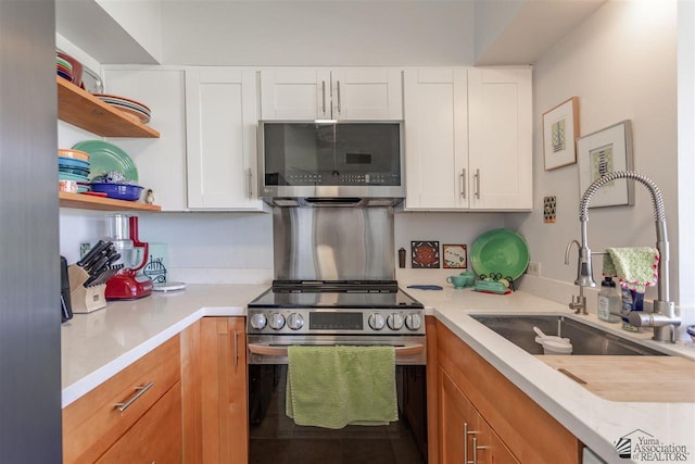 kitchen featuring stainless steel appliances, sink, and white cabinets