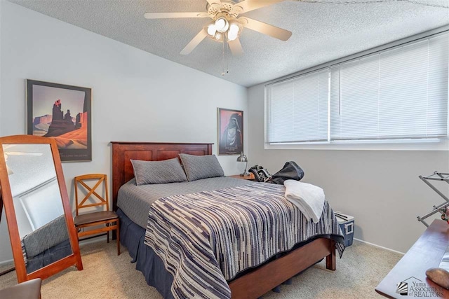 carpeted bedroom with ceiling fan and a textured ceiling