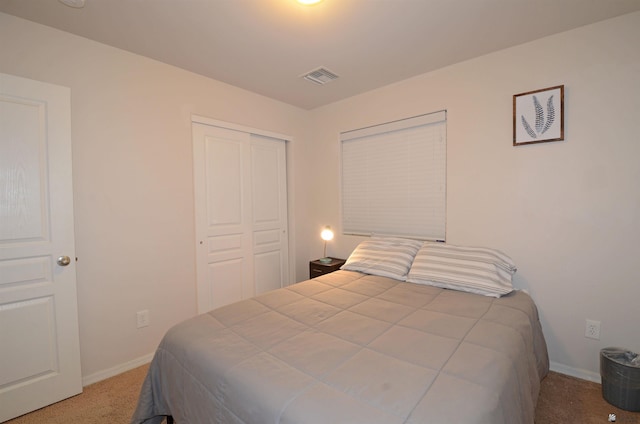 bedroom with a closet, visible vents, carpet, and baseboards