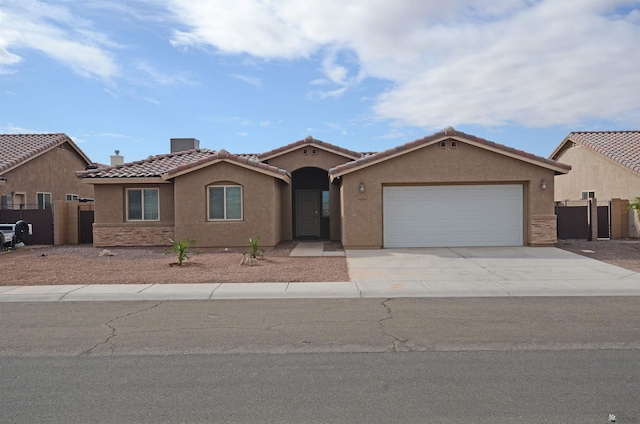 view of front of house featuring a gate, fence, driveway, an attached garage, and stucco siding