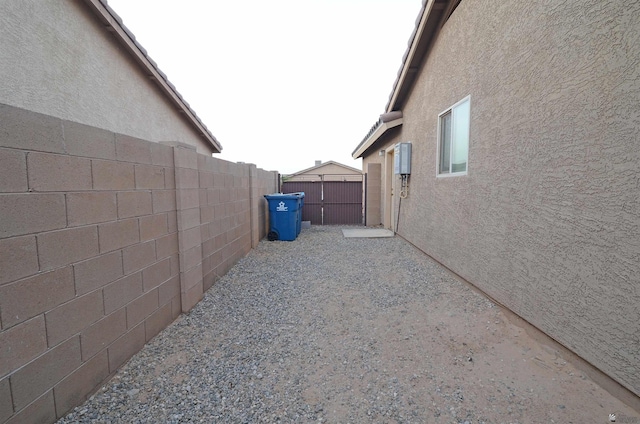 view of side of property featuring stucco siding and a fenced backyard