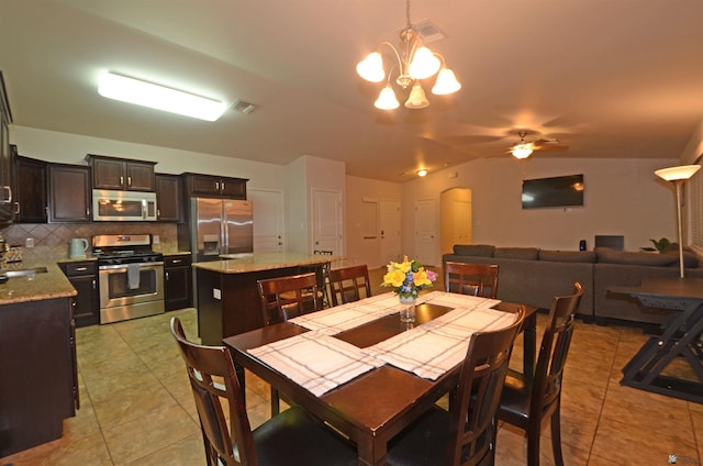 dining space featuring arched walkways, visible vents, light tile patterned flooring, and vaulted ceiling