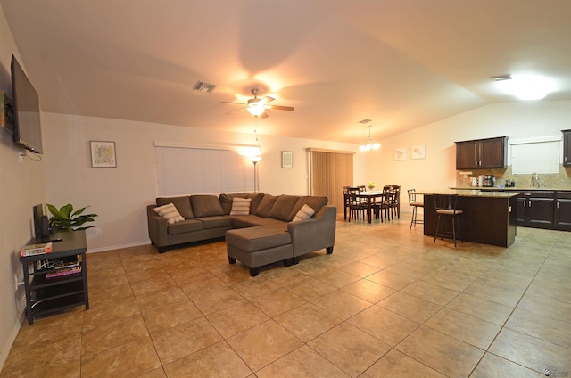 living area with lofted ceiling, light tile patterned floors, ceiling fan with notable chandelier, and visible vents