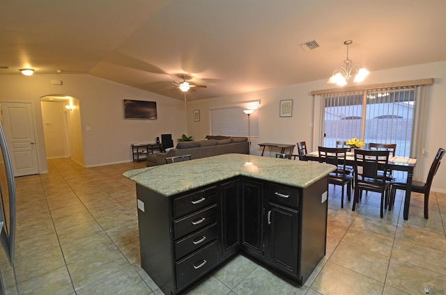 kitchen featuring arched walkways, visible vents, lofted ceiling, and dark cabinets