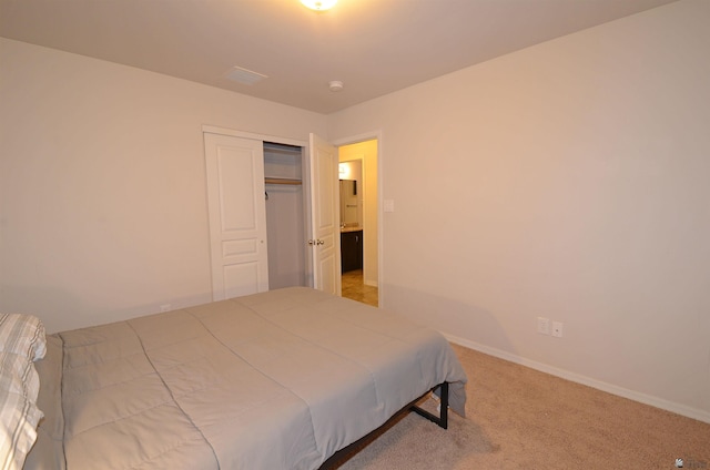 carpeted bedroom featuring a closet and baseboards